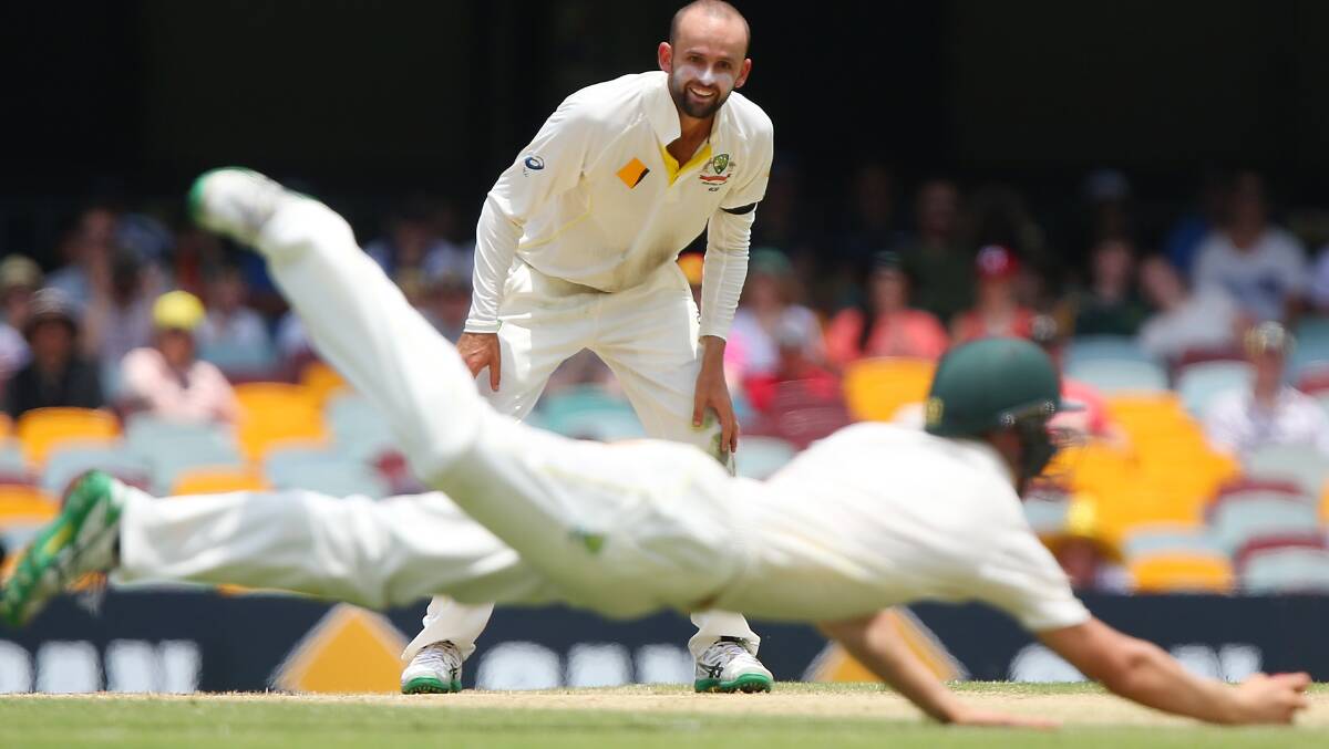 Nathan Lyon of Australia watches substitute fielder Marnus Labuschagne and Redlands Tigers player take a catch to dismiss Varun Aaron of India during day two of the 2nd Test match between Australia and India at The Gabba on December 18, 2014 in Brisbane, Australia. (Photo by Chris Hyde/Getty Images)
