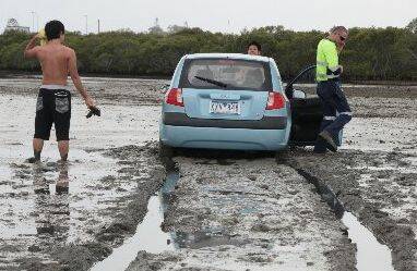 Stuck:  The small car is bogged in the mud at Oyster Point.