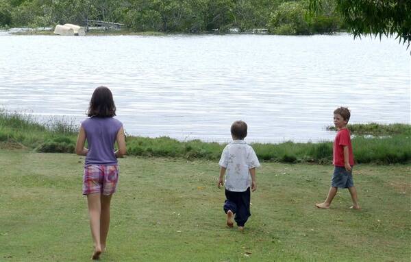 Kids play along the foreshore at Redland Bay during last year's high tides in December.