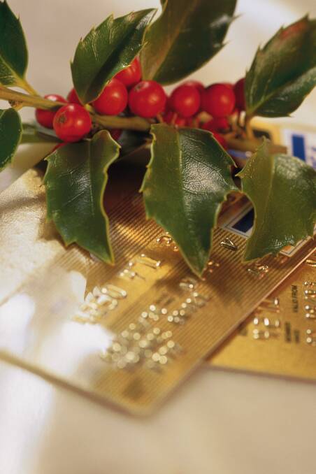 Gold credit cards with sprig of holly