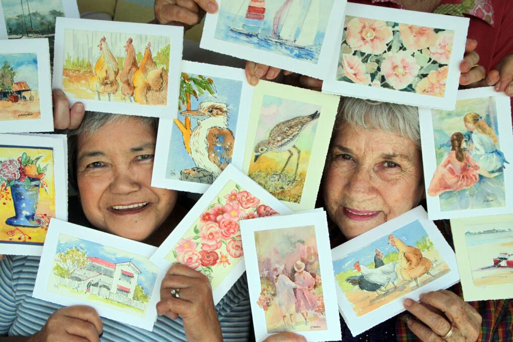 SEPTEMBER: Helen Chaston and Alma Despot of the Coochiemudlo Art Group with some of the original hand painted cards. Photo by Chris McCormack