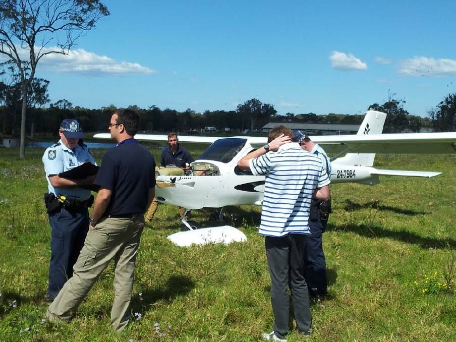AUGUST: Police speak to the pilot of an ultralight plane that crash landed in a Victoria Point field. The pilot was later praised for his cool head after the aircraft's engine malfunctioned. Photo: Stephen Jeffery.