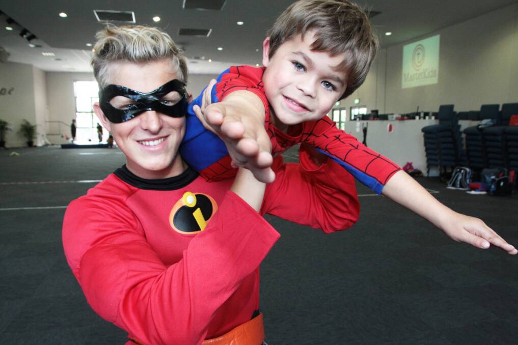 JUNE: MasterKids holiday program - team leader Michael Kelly, 18 of Ormiston gives fellow super hero Greg Macnair, 7 of Thornlands wings. Photo by Chris McCormack