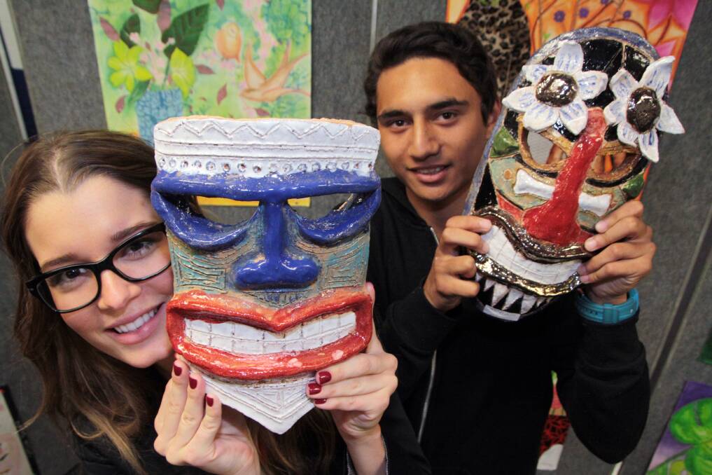 JUNE: Arts Fest event Capalaba State College - Heidi Crick, 23 of Camp Hill holds a tiki mask made by Tammy-Lee Coyne and year 11 art student Jalen Hale-Atkins holds a  tiki mask made by year 11 student Madeline Smith. Photo by Chris McCormack