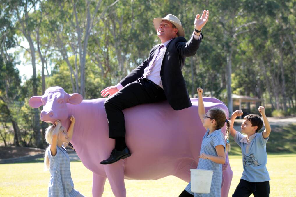 AUGUST: Hilliard State School Principal Andrew Walkers is cheered on by grade 2 students Ella Wiltenburg, McKenzie Parish and Jack Lowe as he rides the Picasso Cow which aims to educate students on where dairy products come from. Photo by Chris McCormack