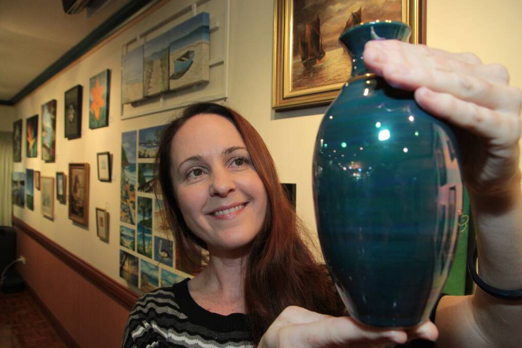 JULY: Salford Waters - Kingfisher Art Show - Nicole Sinden of Springwood eyes off one her numerous purchases on the night, a stoneware vase made by Vivian Wright. Photo by Chris McCormack