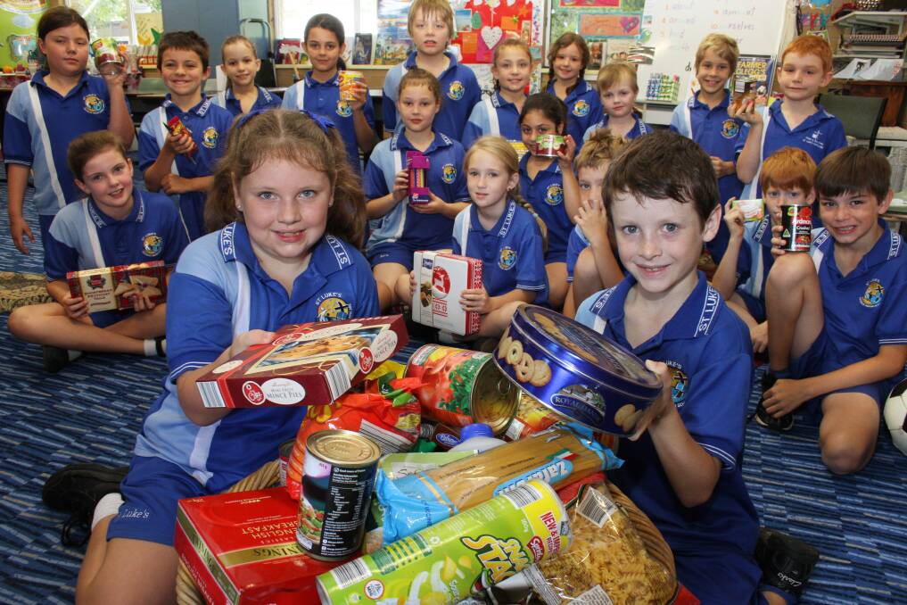 NOVEMBER: St Lukes primary school  Capalaba grade 3 students Olivia Self and Jackson Young with the Christmas hamper bound for St. Vincent de Paul. Photo by Chris McCormack