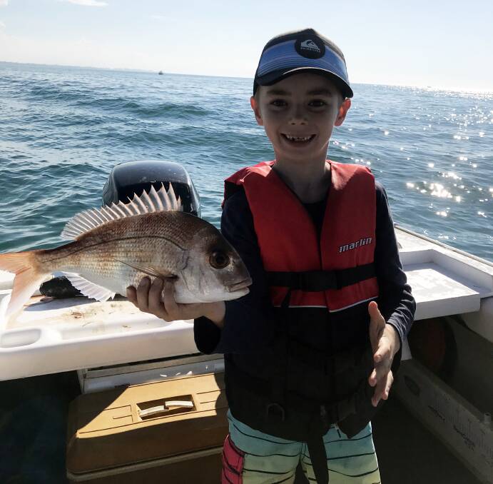 Cooper Lawrence with his first legal snapper caught on a piece of mullet near Peel Island.