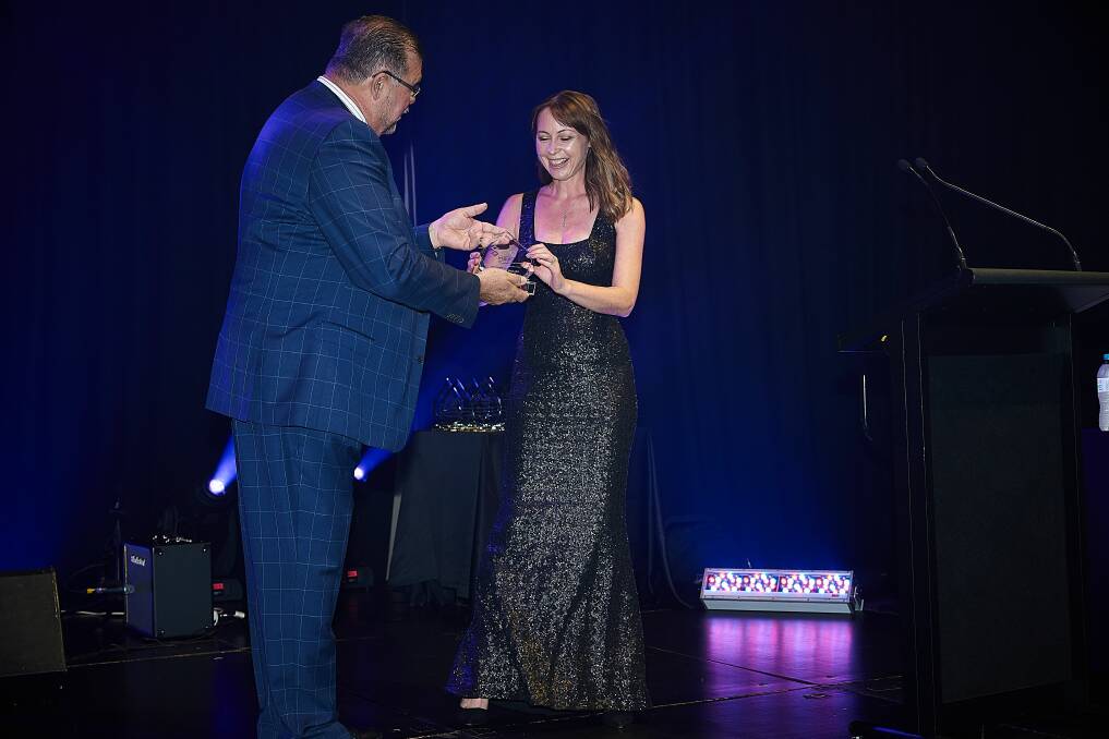 WINNER: Michelle Wright receives her award from REIQ chair Peter Brewer.
