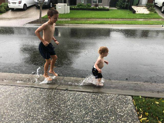 HAVING A BALL: Kids play in the water during heavy rain on Monday. Photo: Jamie Crust