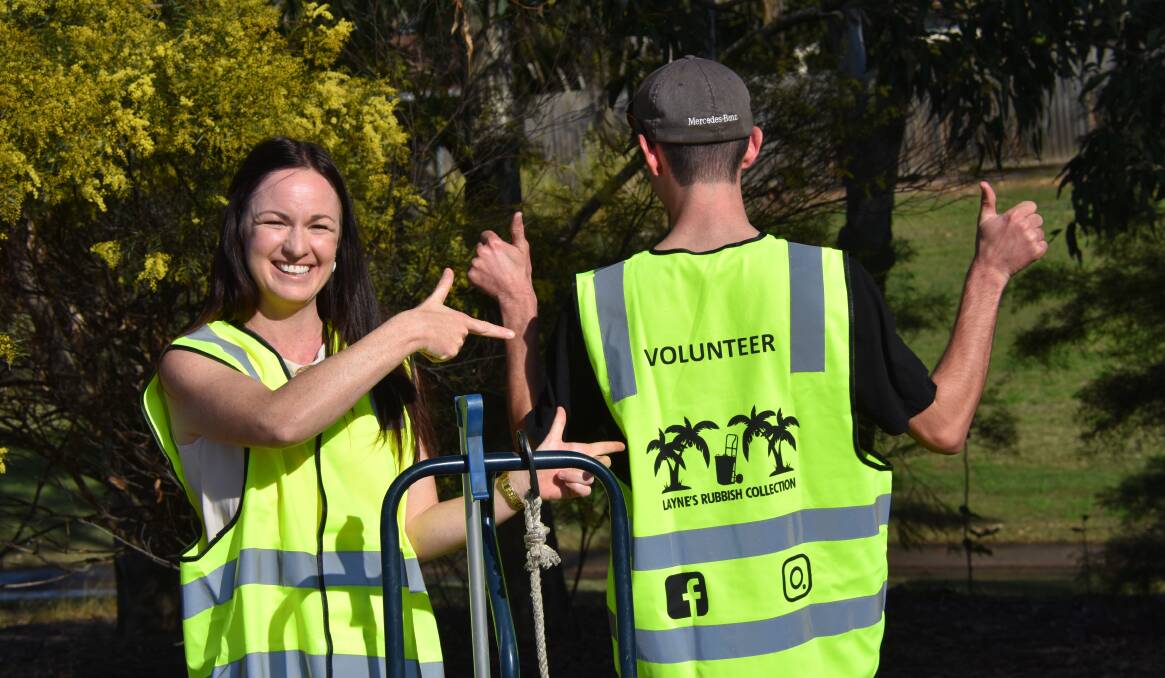 ENVIRONMENT: Volunteer Andrea Stanley with Layne Utz, showing off the volunteer vests.