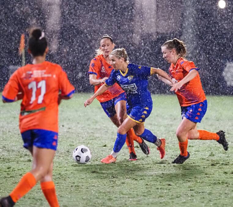 WET WEATHER: Amy Chapman battles in the soggy weather. Photo: Alan Minifie/Capalaba FC