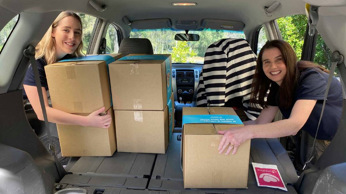 HERE YOU GO: Capalaba Central team members Samantha Pollock and Sue Wormald deliver care packs to vulnerable local residents during the COVID-19 crisis. 