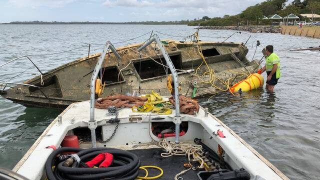 SUNK: Contractors remove an abandoned boat under a state government plan to clean up waterways.