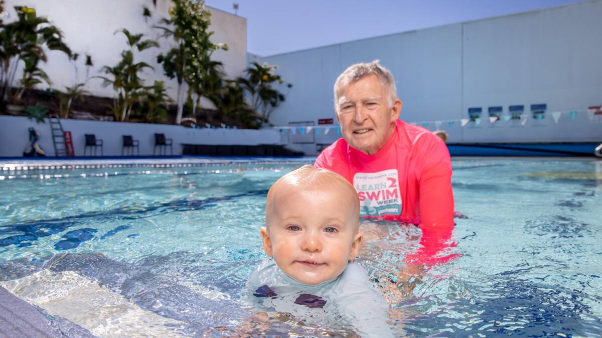 POOL TIME: Swim coach Laurie Lawrence and a toddler. Mr Lawrence has campaigned for years for more toddlers to be taught to swim.