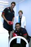 JERSEY WASH: Queensland Reds players Rob Simmons and Samu Kerevie with Disability Services Assistant Minister Jane prentice at the Capalaba Laundretto.