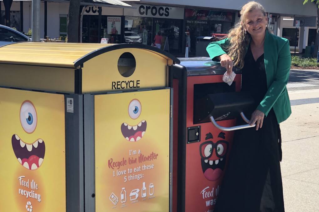 LITTER compactor: Karen Williams at the compacting bin that may cut rubbish collection costs.