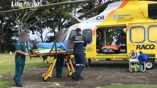 CRASH: The trail bike rider is loaded aboard a rescue helicopter on North Stradbroke Island.