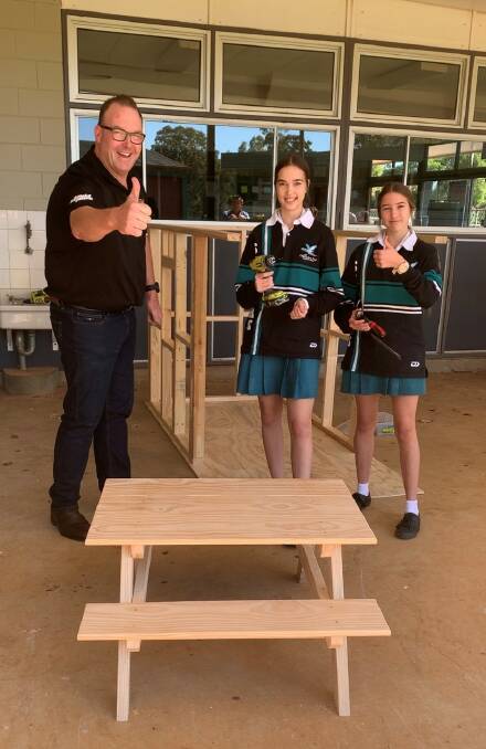 FINE CRAFTING: Adam Gould of Gould Estate Agents with year 12 building and construction class students Meg Thompson and Tiarna Bugden. They are showing off their creation. 