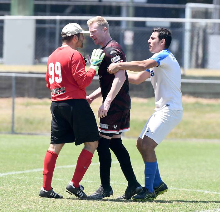 INTENSE GAME: Michael Mrowka has a word with the opposition goalkeeper. The heat on the pitch matched the weather. Photo: Matt McLennan