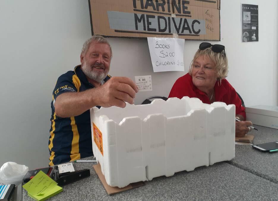 FUNDRAISER: Jan and Deirdre Mulder drawing a raffle ticket during the bookfest to support North Stradbroke Island VMR. 