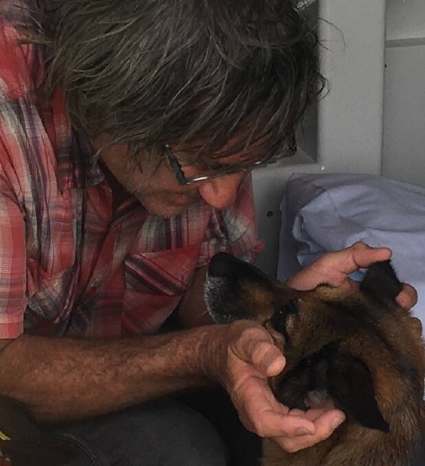 LOVE: The man was reunited with his dog after spending about 15 hours treading water when his boat sunk. 