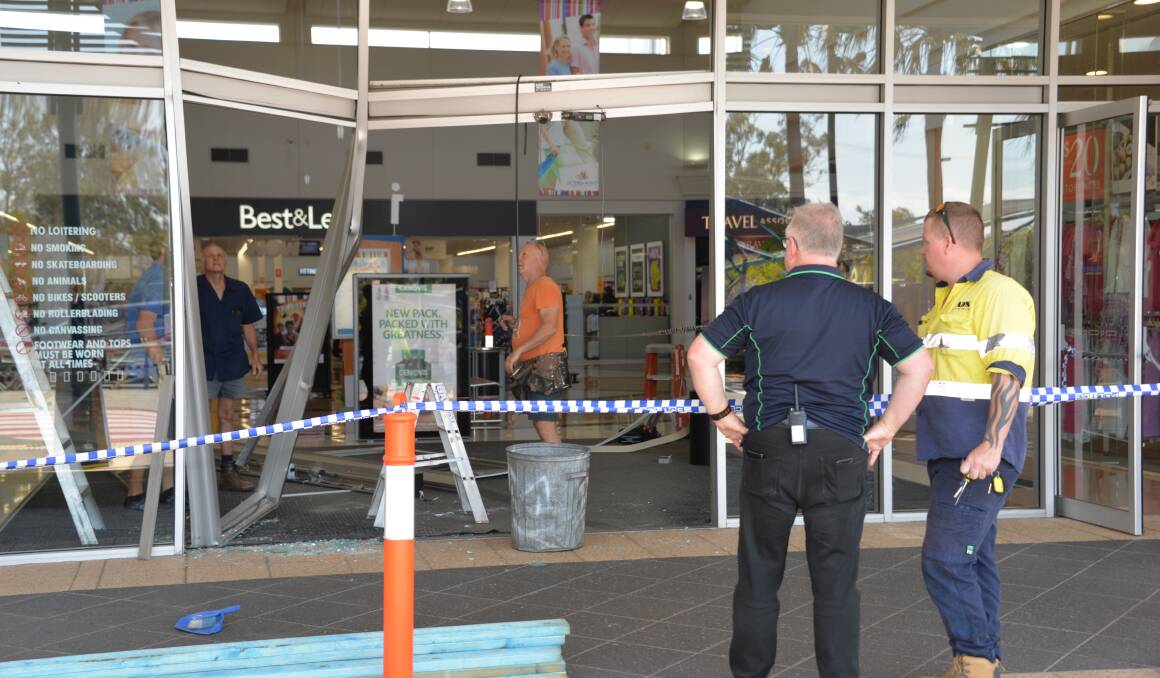 BREAK-IN: Workmen and Victoria Point Shopping Centre management assess the damage on Wednesday morning. 