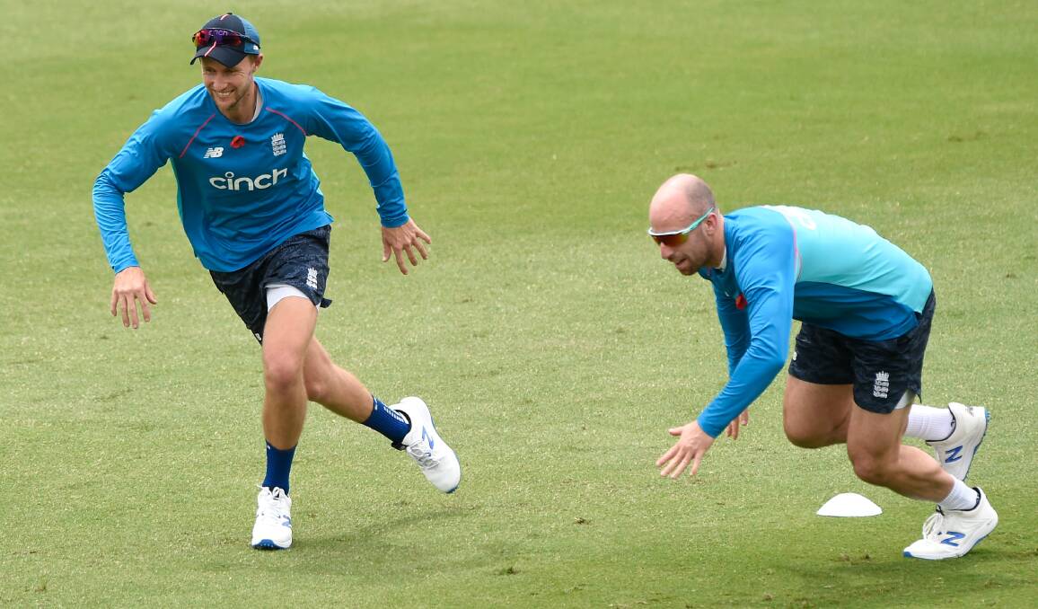 PREPARATION: England captain Joe Root and spinner Jack Leach warm-up for the Ashes at Metricon Stadium. 