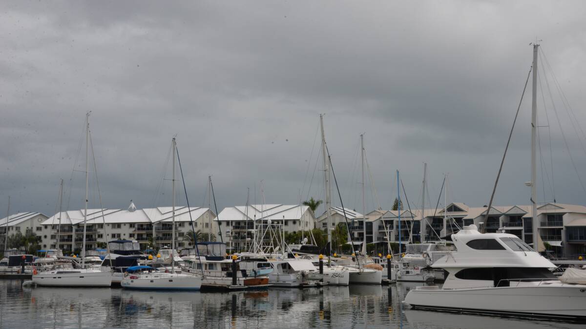 SOGGY: Dark clouds gather over Raby Bay harbour as heavy showers approach the Redlands. Photo: Jordan Crick 