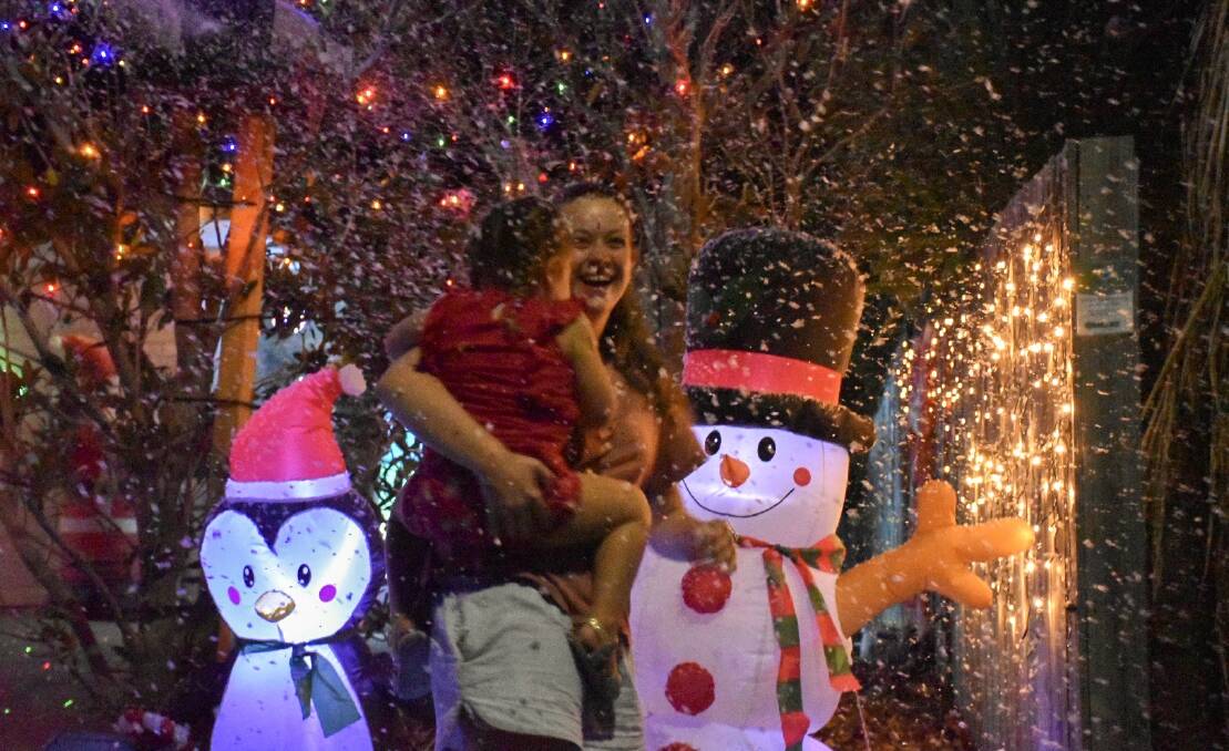 WINTER WONDERLAND: Families enjoy the Christmas lights and faux snow at Woodcrest Close, Redland Bay on a glorious summer's evening. Photo: supplied