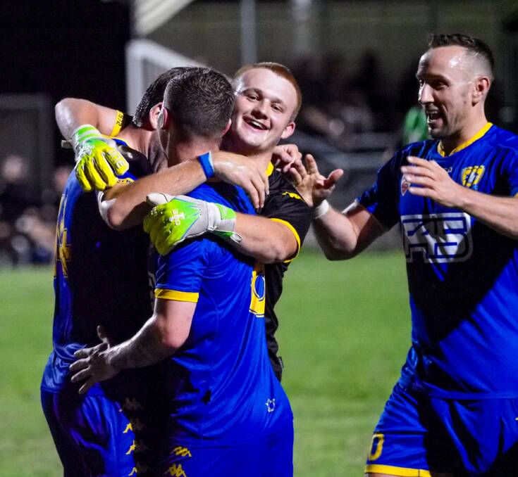 BIG HUGS: Capalaba Bulldogs players celebrate a goal during their 4 - 1 win over Ipswich Knights.