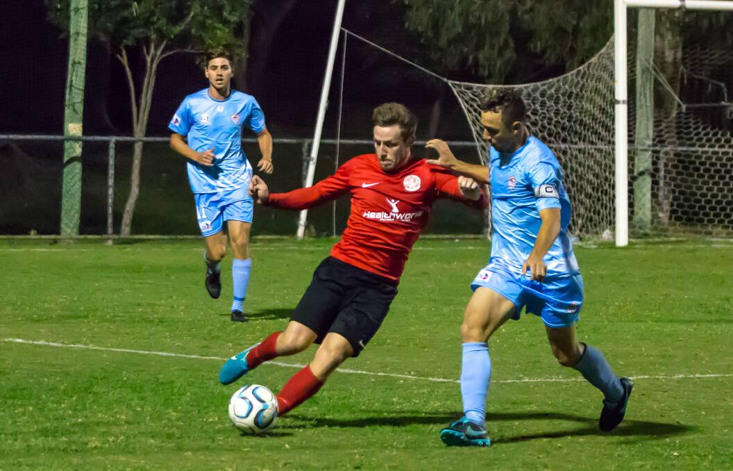 ON ATTACK: The Red Devils' Alex Warrilow get in his cross during their National Premier League match against Cairns FC at the Cleveland Showgrounds Saturday evening.  Pictures: Ray Gardner