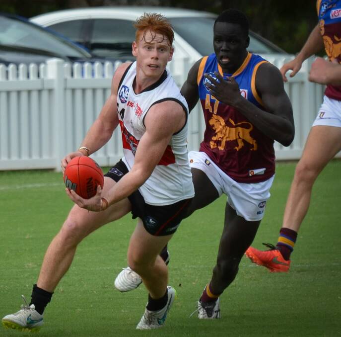 defenders coming: Blake Grewar looks for a pass for Redland Bombers in their pre-season fixture against Brisbane Lions.