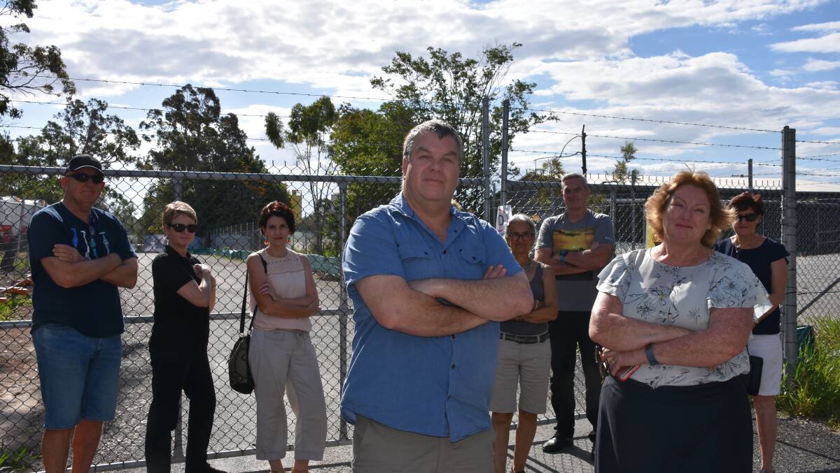 FED UP: Nicholas Forbes and Michelle Melnikoff and some of the disgruntled residents at the gates of the Holey Moley site in Thornlands.