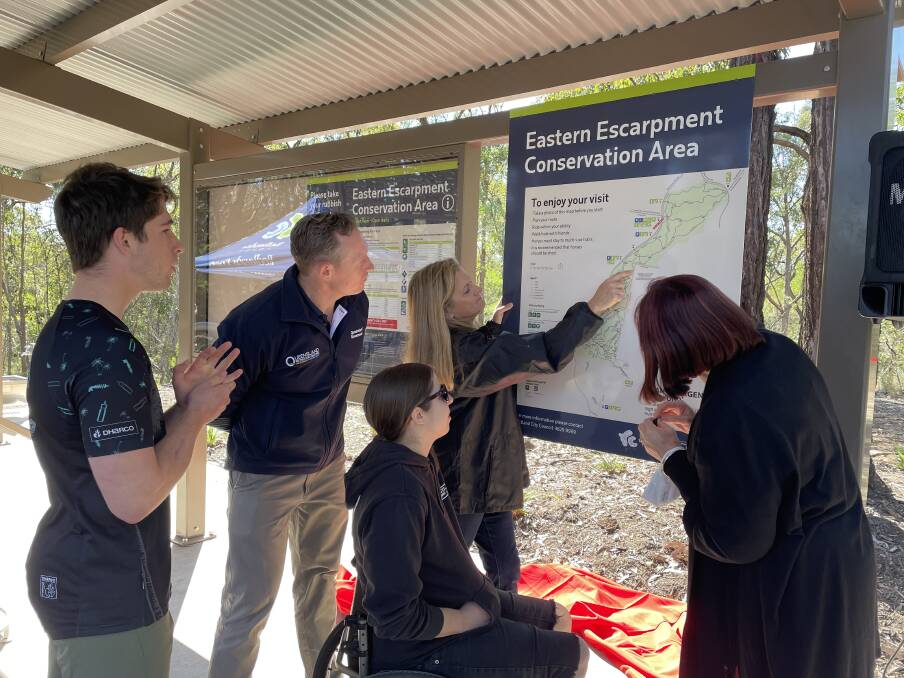 Bailey Meares, Springwood MP Mick de Brenni, mayor Karen Williams, Renee Junga and Cr Julie Talty have a closer look at the trails on the map.