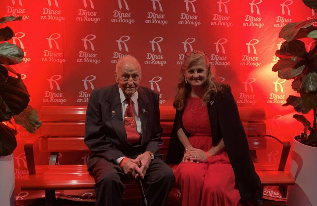TAKE A SEAT: Philanthropist Dan Holzapfel with Mayor Karen Williams on one of the red benches that will be placed in the community. The Red Bench initiative was announced at the Diner en Rouge fundraiser last Saturday.