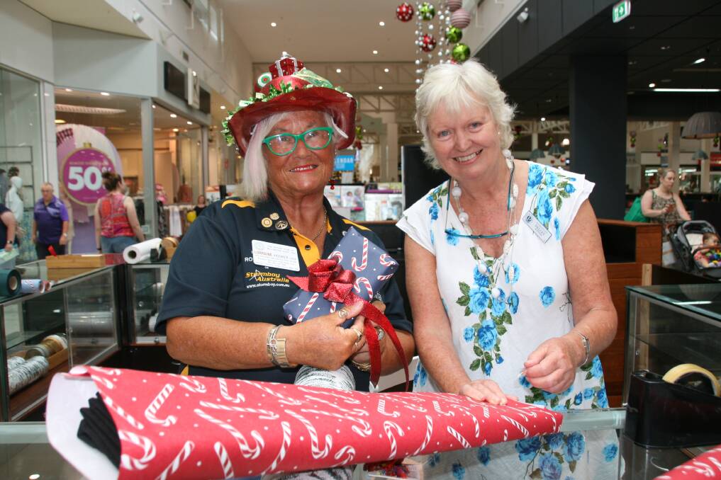 SPARKLING: Lorraine Hooker and Delcey Waterer wrapping Christmas presents at Capalaba Central outside Best & Less.