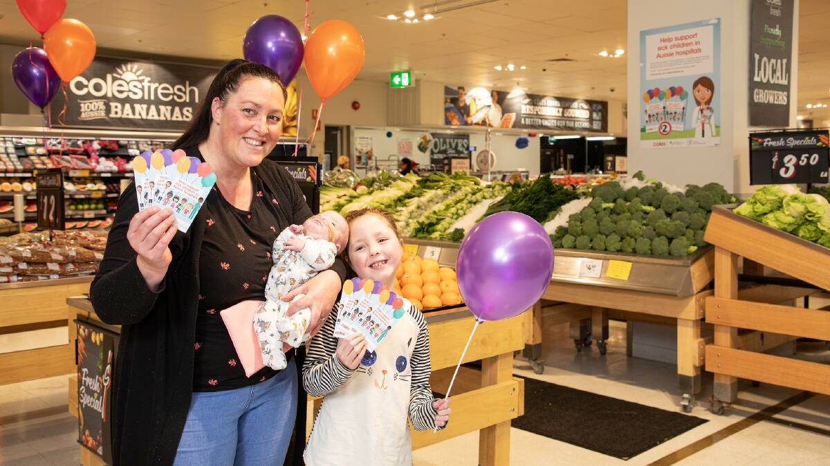SHOPPING: Kate Wood and baby Torvi and daughter Tessa with Curing Homesickness donation cards.
