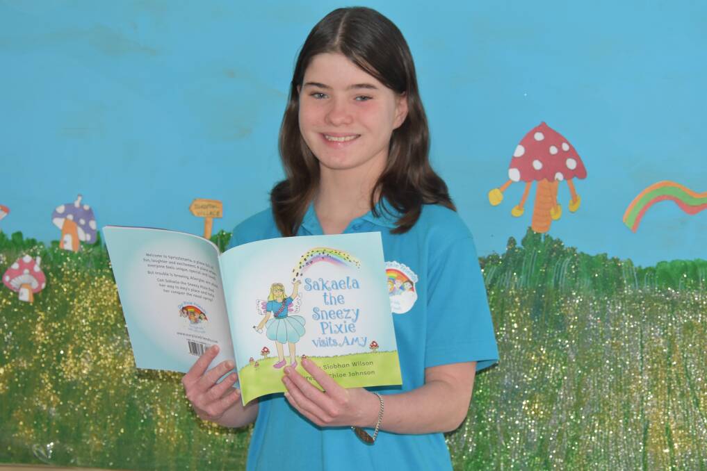 MAGICAL: Young Victoria Point entrepreneur Siobhan Wilson,12, with her book - Sakaela the Sneezy Pixie visits Amy.