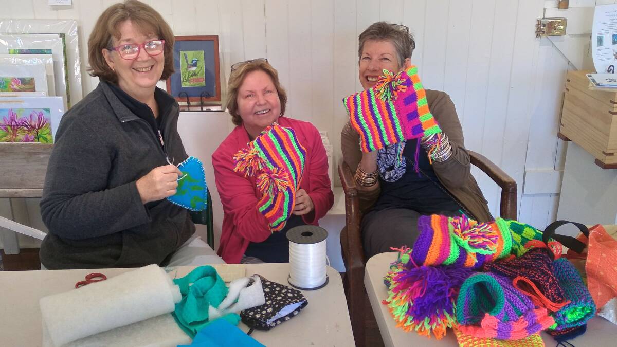 CRAFTY: Old SchoolHouse Gallery members Hilary Wakeling, Caroline Ness and Kate Bray prepare colourful handmade yarn bombing pieces for the gallery. 