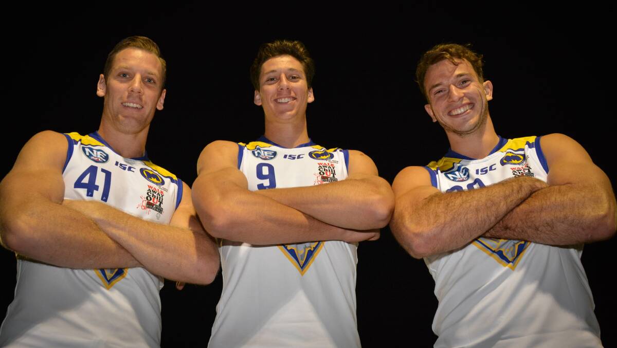 Up for auction: Redlands Bombers players Adrian Williams, Dylan Adkins and Jackson Paine in jerseys that are to be auctioned for a "one punch" charity event this weekend. Photo: Supplied