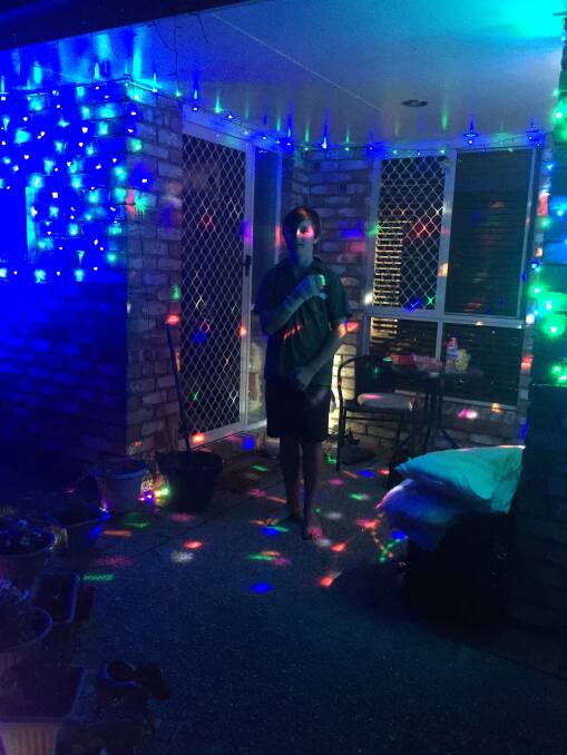 All of the lights: Seth Singleton-Gibbons of Alexandra Hills has been hard at work putting up Christmas lights despite having recently had surgery on his hand. Photo: Supplied