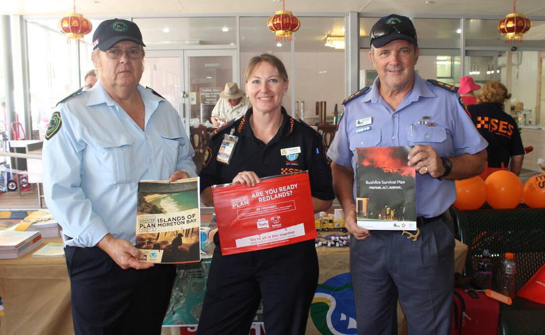 SHARING INFORMATION: Rural Fire Brigade volunteers Kevin Gillard and (right) Larry Hoffman, with Redland City SES local controller and resilience community co-ordinator Clare Barker on Russell Island on Saturday. Photo: Cheryl Goodenough