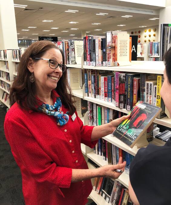 REFURBISHMENTS COMING: A staff member at a Redland City Council library helps a customer ahead of the refurbishments.