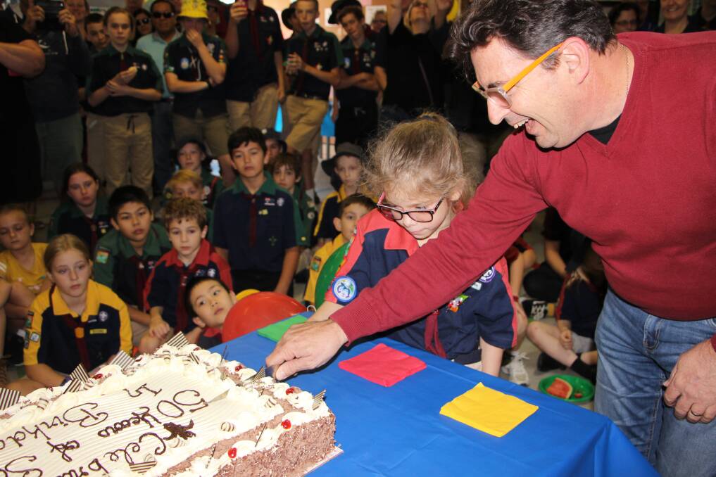 CELEBRATING: Joey Scout Aliyah Byers and Ian Johnson, son of the group founder of Birkdale Scouts, cut the 50th anniversary cake.