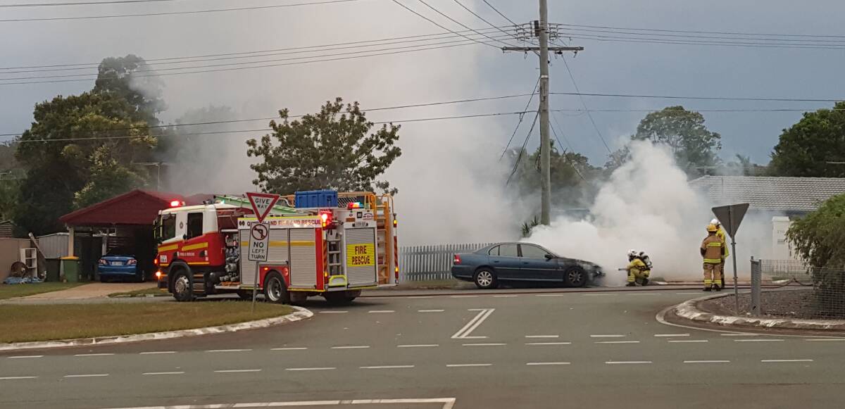 Crew from the Capalaba Fire Station extinguish a fire from the bonnet of a vehicle in Alexandra Hills. Photo: Matt Goode