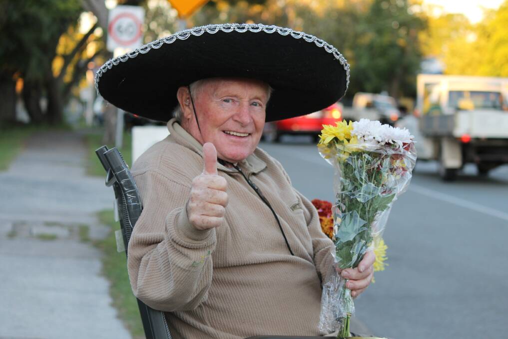 THUMBS UP: Birkdale flower seller Walter Graves says Queenslanders are really friendly. His challenge is to get a thumbs up from every car that drives past. Photo: Cheryl Goodenough