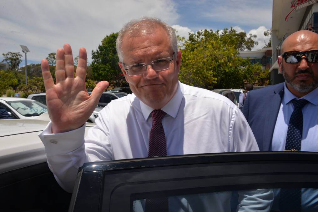 AT CLEVELAND: Prime Minister Scott Morrison waves as he gets into his car after a visit to the Redlands. Photo: Brian Williams