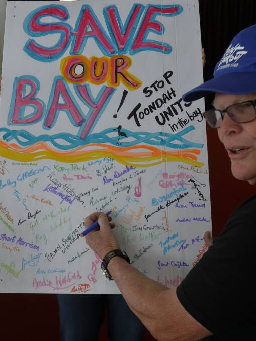 LOBBY GROUP: Cleveland resident Peter Hogan signs a poster protesting against the Toondah Harbour development at a meeting organised by lobby group Redlands 2030. Photo: Chris Walker