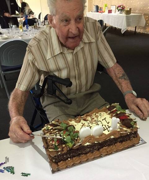 CELEBRATING: Bill Gardner cuts the cake at a celebration for his 100th birthday at the Redland Bay Golf Club.